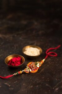 Premium Photo Raksha bandhan with an elegant rakhi rice grains and kumkum a traditional indian wrist band which is a symbol of love between brothers and sisters 1