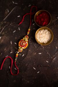Premium Photo Raksha bandhan with an elegant rakhi rice grains and kumkum a traditional indian wrist band which is a symbol of love between brothers and sisters
